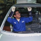 An employee in Ford's mexico-based factory works on a car; The U.S. automaker's international expansion has caused a 16 percent drop in it's American-employed workforce.
