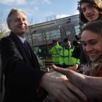 WikiLeaks founder Julian Assange shakes hands with supporters: A new report has revealed that the world-famous secret spiller enforces strict confidentiality rules on his employees.