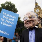 A man wearing a Rupert Murdoch mask protests outside Britain's parliament on Tuesday: Some commentators believe News Corp. should force Murdoch to step down as CEO in the wake of a phone-hacking scandal.