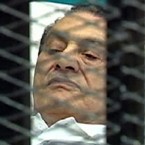 Former Egyptian President Hosni Mubarak lies in a hospital bed in the defendant's cage of a courtroom in March 2011.