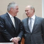 Exxon CEO Rex Tillerson (left) speaks with Russian Prime Minister Vladimir Putin (right) during the signing ceremony for a deal that gives the energy giant access to oil in the Russian Arctic.