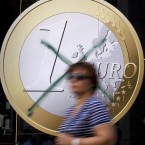 A woman walks by a crossed-out Euro advertisement in a Madrid shop: While the common market solution was meant to strengthen Europe, it hasn't unfolded as planned.