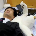 A man tests a robotic polar bear pillow that gently tickles the face of a snoring sleeper so he'll turn over and breathe normally.