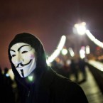 A masked Occupy Wall Street protester walks across the Brooklyn Bridge Thursday night: Hundreds of Occupiers were arrested during the two-month-old movement's "Day of Action."