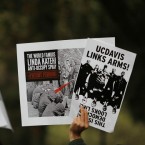 Occupy protesters hold signs during a demonstration at UC Davis: New footage of the now-infamous pepper spray incident reveals that protesters knew the assault was coming well in advance.