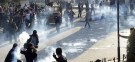 Syrian protesters cover their faces as tear gas is fired by the regime's soldiers, who are continuing their crackdown despite the presence of Arab League observers.