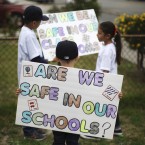 Students of Miramonte Elementary School in Los Angeles hold signs during a march: Two teachers at the school have been charged with sexual abuse and the entire staff replaced.