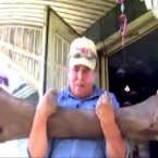 An Iowa man hefts the woolly mammoth femur bone he and his two sons found in the woods behind their house.