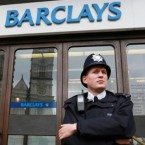 Police wait for protesters outside a London Barclays branch: Barclays has agreed to pay more than $450 million to settle charges that it manipulated a benchmark interest rate.