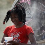 Kierra Waller, a 9-year-old girl from Baltimore, tries to beat the heat with a misting fan during an NFL football training camp practice in Virginia.