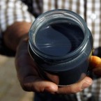 French apiarist Andre Frieh holds up samples of honey: The bright blue sample is believed to have been contaminated by a plant involved in candy production in Ribeauville, France.