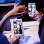 People interact with the Samsung Galaxy S III on its launch day in June: The Korean manufacturer is offering a mini version, shrinking the phone's 4.8-inch display to four inches.