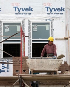 Workers apply brick facing to a group of new row houses in Chicago on Oct. 17.