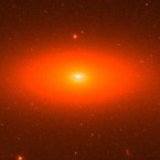 The small flattened galaxy (center) has a black hole equivalent to 17 billion suns.