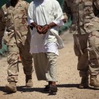 U.S. military guards move a detainee inside Guantanamo in 2010.