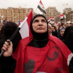 An Egyptian woman holds a national flag as she listens to speakers in Tahrir Square on Dec. 4.