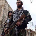 Free Syrian Army fighters carry weapons on a street in Aleppo's al-Amereya district on Dec. 12.