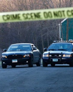 Newtown police officers watch over a blocked-off section of Yogananda Street on Saturday morning, where the the mother of Adam Lanza, the alleged shooter, was killed at her home on Friday.