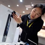 An employee cleans an advertisement plate at an Apple store in Wuhan, China, on the eve of iPhone 5's Chinese debut.