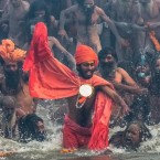 Naga sadhus run in to bathe in the waters of the holy Ganges river during the auspicious bathing day of Makar Sankranti of the Maha Kumbh Mela on January 14, 2013 in Allahabad, India.&nbsp;